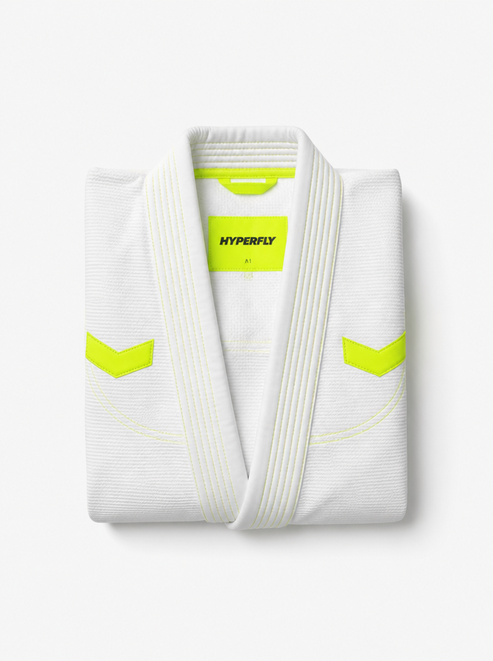 Minimalist shot of a folded white jiujitsu gi with neon accents
